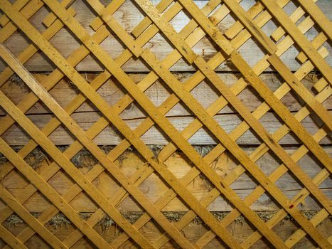 Old wooden wall of an old house in lattice pattern with rough texture.