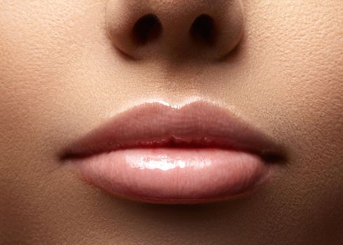 Close-up perfect natural lip makeup beautiful female mouth. Plump sexy full lips. Macro photo face detail. Perfect clean skin, fresh lip make-up. Beautiful spa tender lips