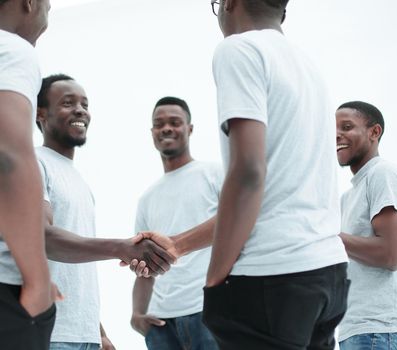 close up. smiling guys shaking hands. isolated on white background