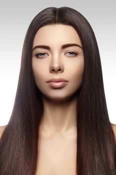 Beautiful yong woman with long straight brown hair. Sexy fashion model with smooth gloss hairstyle, keratin treatment