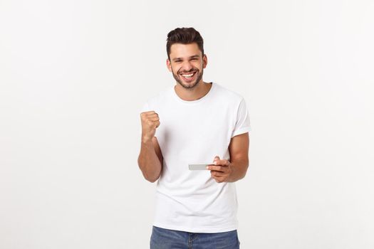 portrait of a young man playing video games on mobile phone on gray background