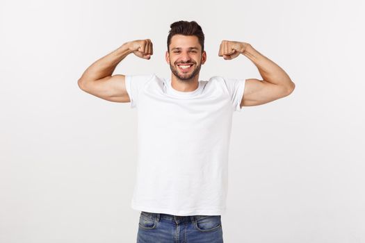 Handsome fit young funny bearded man pointing to his bicep and smiling on white background.