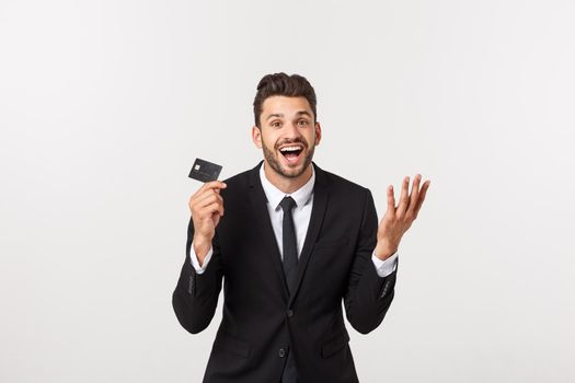 Surprised, speechless and impressed handsome caucasian businessman in classic suit showing credit card, say wow, standing white background astonished.