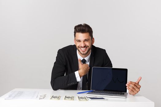 businessman sitting at desk point finger at isolated white laptop screen with empty copy space, handsome young business man.