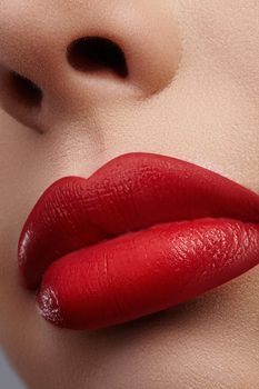 Close-up of female lips with bright makeup. Macro of woman's face. Fashion lip make-up with red gloss.Red lipgloss makeup on full female lips