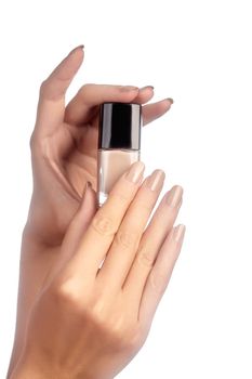 Manicured nails with natural nail polish. Manicure with beige nailpolish. Fashion manicure. Shiny gel lacquer in bottle.