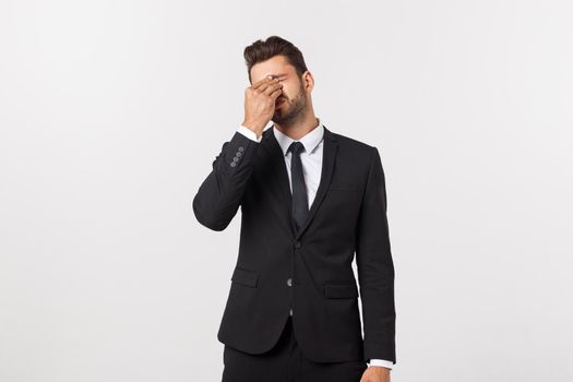 Portrait of modern serious business person in dark suit and contemplating with both hands resting at head, isolated on white background