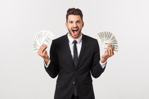 Portrait of a satisfied young businessman holding bunch of money banknotes isolated over white background