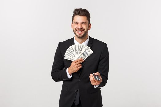 Portrait of a happy smiling man holding bunch of money banknotes and showing credit card isolated over white background