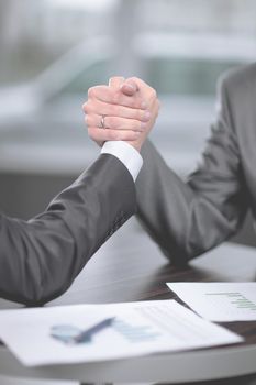 close up. two businessmen are engaged in arm wrestling at a Desk.