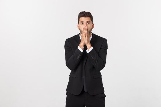 Well dressed man in the studio emphasize thoughtful thinking, think carefully and try to choose to hold hands and stand against the white background