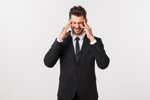 Portrait of modern serious business person in dark suit and contemplating with both hands resting at head, isolated on white background