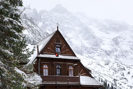 The old wooden house on the background of the winter mountains