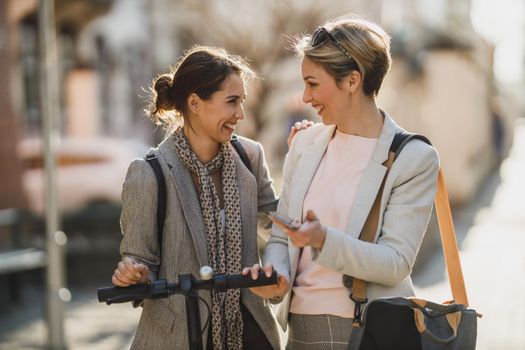 A two successful businesswomen having a quick break and chatting while walking through the city.