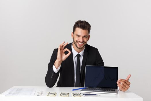 Closeup portrait of cheerful guy showing OK sign while resting on chair in office being satisfied isolated over gray background