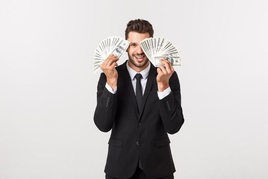Portrait of a satisfied young businessman holding bunch of money banknotes isolated over white background