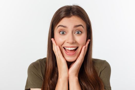 Close-up portrait of surprised beautiful girl holding her head in amazement and open-mouthed. Over white background.