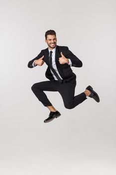 Portrait of a happy businessman jumping in air against isolated white background