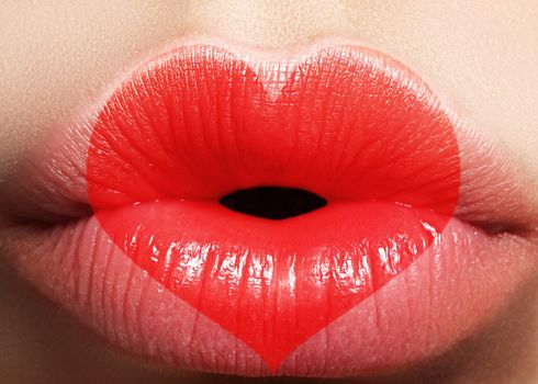 Valentine Heart on beautiful female Lips. Sweet Kiss. Love Makeup for Valntines Day. Cute Shape Heart like Symbol of Love. Celebrate Lip Make-up on macro shoot.