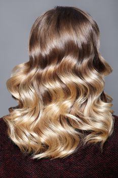 Beautiful and Shiny Curly Hair. Fashion Girl With Healthy Long Wavy Hair. Beauty Blonde Woman Back View. Hair Extension, Permed Hair. Retro Style. Gloss Curles Hairstyle