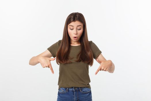 Portrait happy and surprised young lady standing isolated over grey background. Looking camera pointing