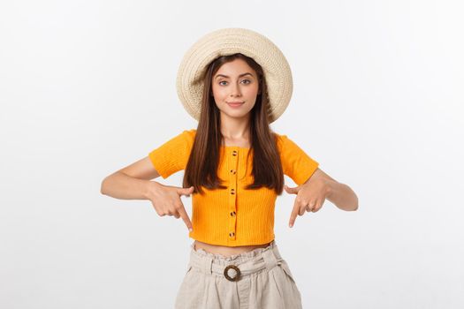 Teenager girl on summer vacation surprised and pointing finger on copy space over isolated white background