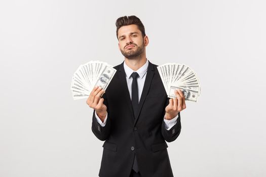 Portrait of a satisfied young businessman holding bunch of money banknotes isolated over white background