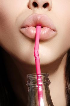 Glamour closeup of woman's lips drinking with pink straw. Natural makeup, full lip. Cute fashion summer look with bottle of water. Healthy lifestyle