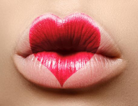 Valentine Heart on beautiful female Lips. Sweet Kiss. Love Makeup for Valntines Day. Cute Shape Heart like Symbol of Love. Celebrate Lip Make-up on macro shoot.