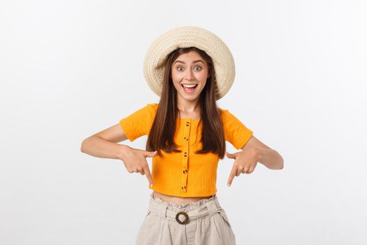 Teenager girl on summer vacation surprised and pointing finger on copy space over isolated white background