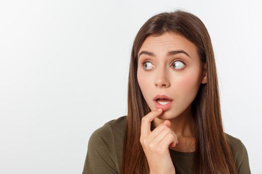 Close-up portrait of surprised beautiful girl holding her head in amazement and open-mouthed. Over white background.