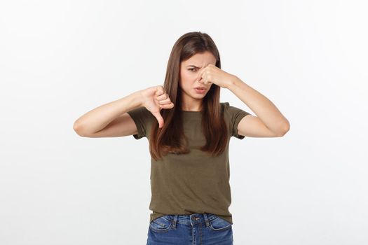 disgusted young blonde closing her nose with her fingers. Isolated over white background