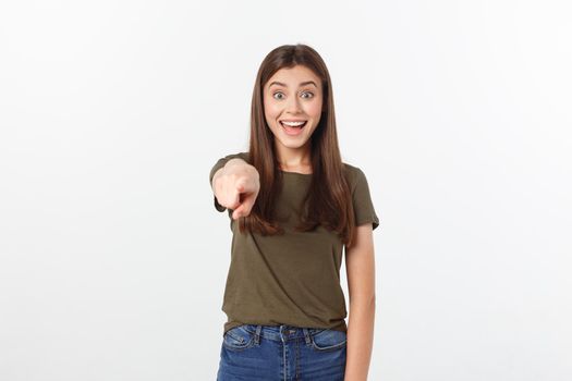 Portrait happy and surprised young lady standing isolated over grey background. Looking camera pointing