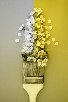 Demonstrating trendy colors 2021 - Gray and Yellow. Color of the year 2021. Illuminating, Ultimate gray. Paintbrush with flowers. Plant background