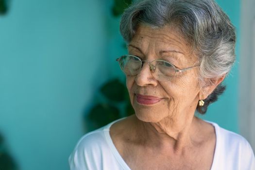 Photo of an old woman wearing glasses. Her skin is wrinkled and her hair has a lot of gray