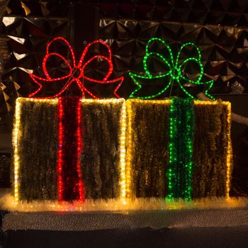 Christmas decorations in the form of boxes with gifts on a city street on Christmas night