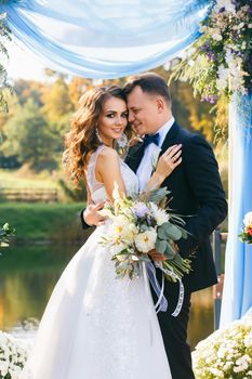 creative stylish wedding ceremony elegant curly bride and groom outdoors on the background the lake