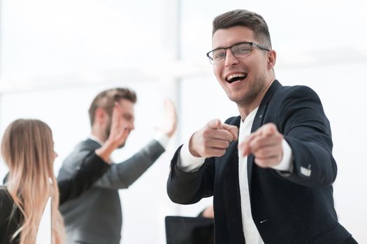 close up. cheerful business man standing in the office and pointing at you.