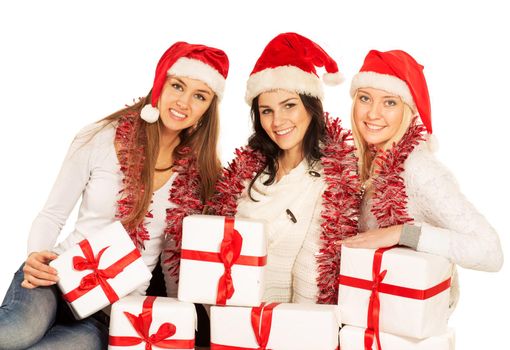 three happy girls with Christmas gifts and decorations