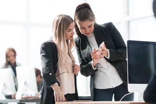 two young employees reading a message on their smartphone. office workdays