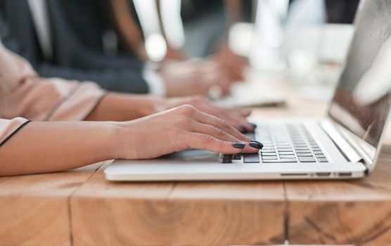 close up. a business woman uses a laptop in the workplace.people and technology