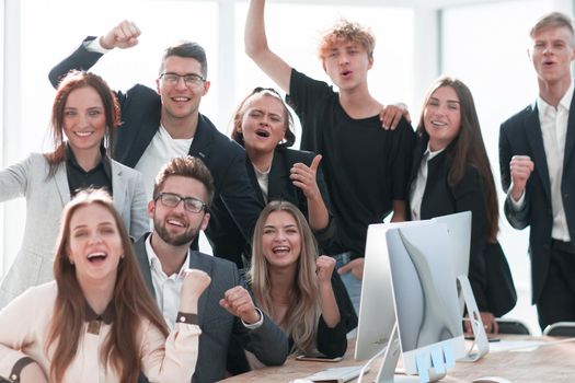 close up. a jubilant business team is cheering near the desktop. concept of successful work