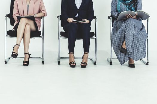 Business people job applicants sitting and waiting on chairs in office. Job application and recruitment concept.