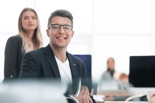 close up. smiling business man sitting at an office Desk.