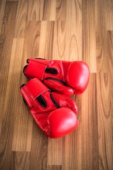Red boxing gloves on wood background. Sport and healthy lifestyle concept.