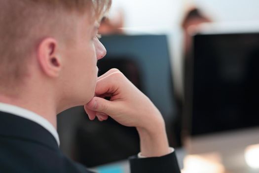 close up. brooding young businessman sitting at an office Desk