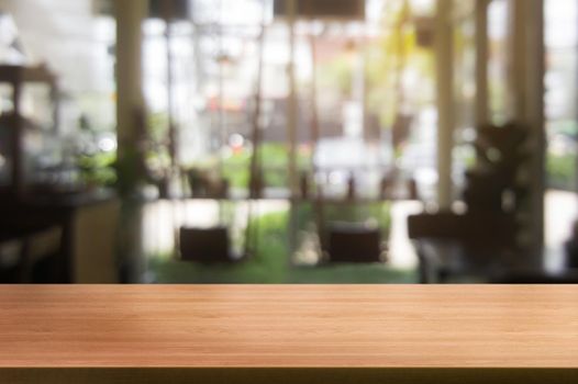 Wood table in blurry background of modern restaurant room or coffee shop with empty copy space on the table for product display mockup. Interior restaurant counter design concept.