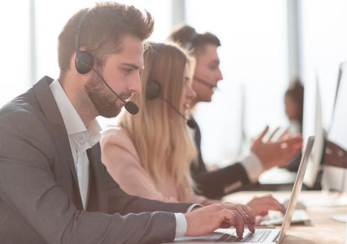 close up. call center operators using laptops to work with clients.