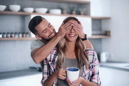 close up. happy man joking with his girlfriend in the kitchen in the morning