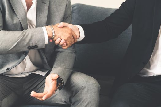 Businessman handshake with another businessman partner in modern workplace office. People corporate business deals concept.